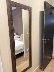 a mirror in front of a bedroom with a bed at Le Col Getaway Virage 5 in Le Bourg-dʼOisans