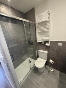 a bathroom with a toilet and a glass shower at Le Col Getaway Virage 5 in Le Bourg-dʼOisans