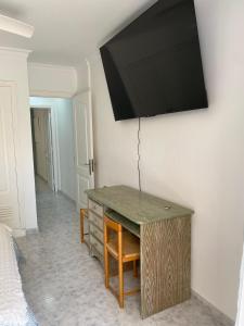 a room with a desk with a television on the wall at Cura Marina in Playa del Cura
