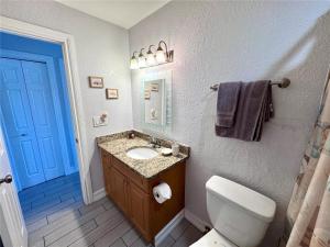 a bathroom with a toilet and a sink and a blue door at 1+1 Large condo Sarasota in Sarasota