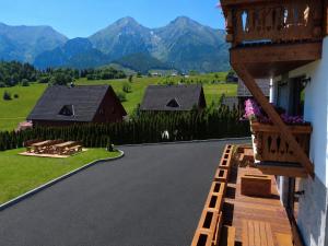 a house with a balcony with a view of the mountains at Apartmány Dominek in Ždiar