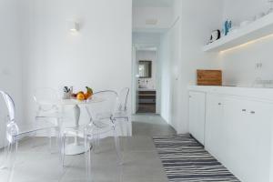 a white kitchen with a white table and chairs at Flag Suites in Pollonia