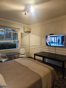 a bedroom with a bed and a flat screen tv at Mansão Morumbi 91 in São Paulo