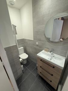 a bathroom with a sink and a toilet and a mirror at Le Col Getaway Virage 6 in Le Bourg-dʼOisans +5 photos