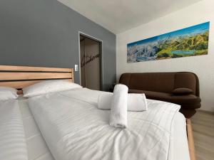 a bedroom with a large white bed and a chair at Apartment Essreithweg Kaprun by Jara in Kaprun +24 photos