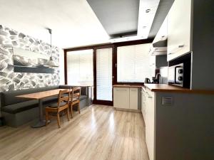 a kitchen with a table and chairs in a room at Apartment Essreithweg Kaprun by Jara in Kaprun