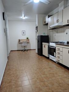 an empty kitchen with a table and a chair in it at Casa amplia 3 dormitorios, 2 baños - Smart TV 50" - Entrada Autónoma - Pileta de Verano in Mendoza +34 photos