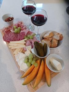 a tray of cheese and meats and glasses of wine at La Source in Angoville