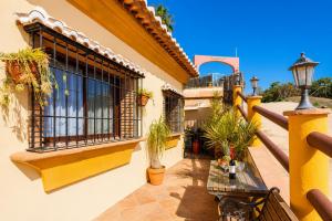 a balcony of a building with a table and potted plants at Villa Las Palomas 2 in Nerja