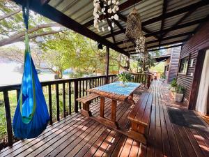 a wooden deck with a picnic table and a hammock at Stella Maris Cabanas in Ponta do Ouro