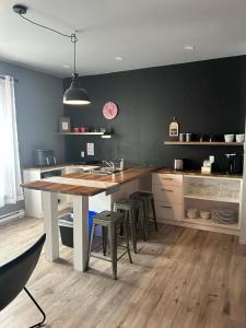 a kitchen with a table and some stools in it at Pavillon Beauséjour in Amqui