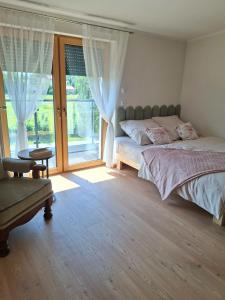 a bedroom with a bed and a large window at Niwy8Rooms in Oświęcim
