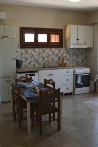 a kitchen with a table and chairs and a stove at Το περασμα in Panormos Kalymnos