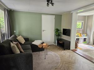 a living room with a couch and a table at Madeliefje - Familie camping in Raalte in Raalte