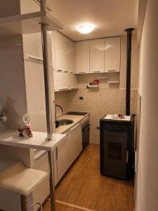 a small kitchen with white cabinets and a sink at Golden Lux in Berane