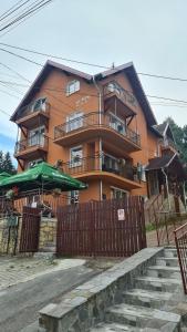 a large orange building with a fence in front of it at La Flori in Sovata