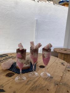 a group of three wine glasses on a wooden table at Pousada Nosso Sonho in Natal +20 photos