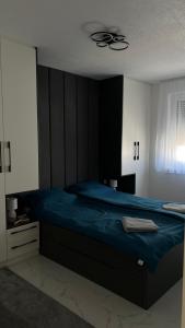 a bedroom with a bed and a ceiling fan at Apartman Dzo in Modriča