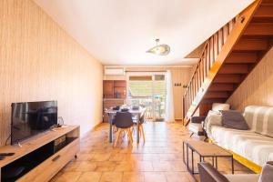 a living room with a couch and a tv and a table at La Brise de Valras in Valras-Plage