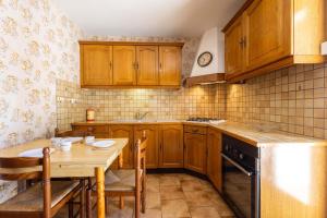 a kitchen with wooden cabinets and a table and a sink at La Brise de Valras in Valras-Plage