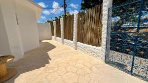 a fence with a gate and a patio at Pousada Nosso Sonho in Natal