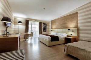 Pokój hotelowy z łóżkiem i biurkiem w obiekcie Hotel Pineta Wellness & Spa w mieście Ruvo di Puglia +35 zdjęć