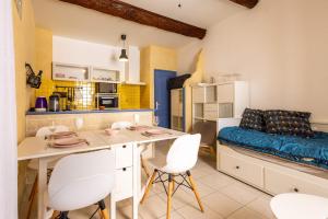 a kitchen with a table and chairs in a room at Charme et Confort A vnedres in Vendres