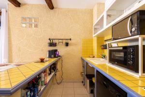 a kitchen with yellow tiles on the wall at Charme et Confort A vnedres in Vendres