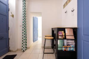 a hallway with a stool and a blue door at Charme et Confort A vnedres in Vendres +7 photos