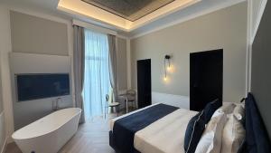 a hotel room with a tub and a bed and a bathtub and a television at Palazzo Montella in Naples