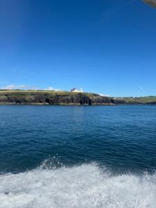 a boat in a large body of water at Waterfront Apartment in Dingle +3 photos