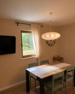 a dining room table with chairs and a television at Magiczne Roztocze in Koszele