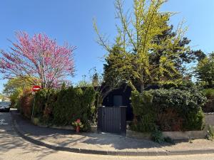 a street with a gate and trees and a stop sign at Maisonnette Indépendante avec Piscine & Jacuzzi in Mittelhausbergen