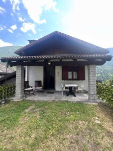 a house with a table and chairs in front of it at Anza Village - Ds Hüüsji 1 in Vanzone