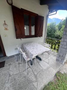 a table and chairs sitting on a patio at Anza Village - Ds Hüüsji 1 in Vanzone