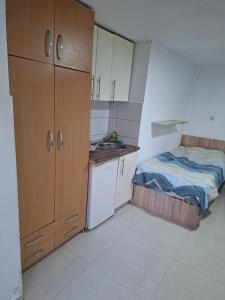a small kitchen with a bed and a sink at Dama 3 in Vojnica