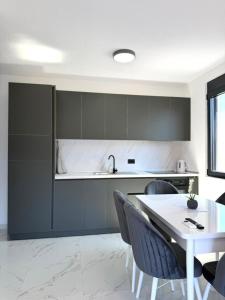 a kitchen with a white table and chairs and a counter at Raba Apartments in Donji Štoj