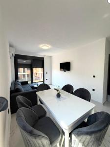 a living room with a white table and chairs at Raba Apartments in Donji Štoj