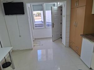 a kitchen with a white tile floor and a door at Dama 3 in Vojnica