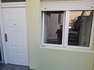 a white door with a window next to a building at Dama 3 in Vojnica