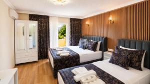 a hotel room with two beds and a window at Olive Branch Hotel in Ayvalık