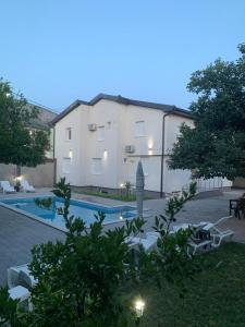 a large building with a swimming pool in front of it at Villa Paradiso By Italy in Mostar