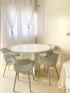 a white table and chairs in a room at Pousada Acessus Work - Proximo da UniEvangelica e Hospital HEANA in Anápolis