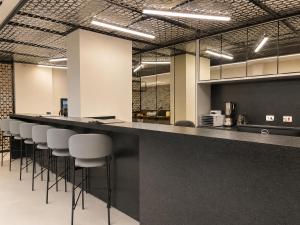 a bar with white stools in a room at Bristol Exceler Campo Grande in Campo Grande +17 photos