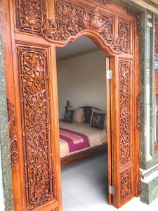 un gran marco de madera con una cama en una habitación en Sapta House en Ubud