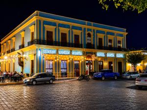 a large building with cars parked in front of it at Hotel Santa Elena in El Fuerte