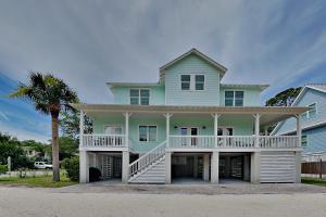a large blue house with a porch and a palm tree at Billfish in Tybee Island