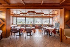 a restaurant with tables and chairs in a room at VILLA NUOVA in Romeno +49 photos