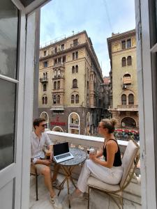 a man and woman sitting on a balcony with a laptop at Velvet city view in Cairo