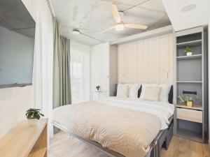 a bedroom with a large bed with a ceiling fan at NanoApart by Solarento in Warsaw +86 photos